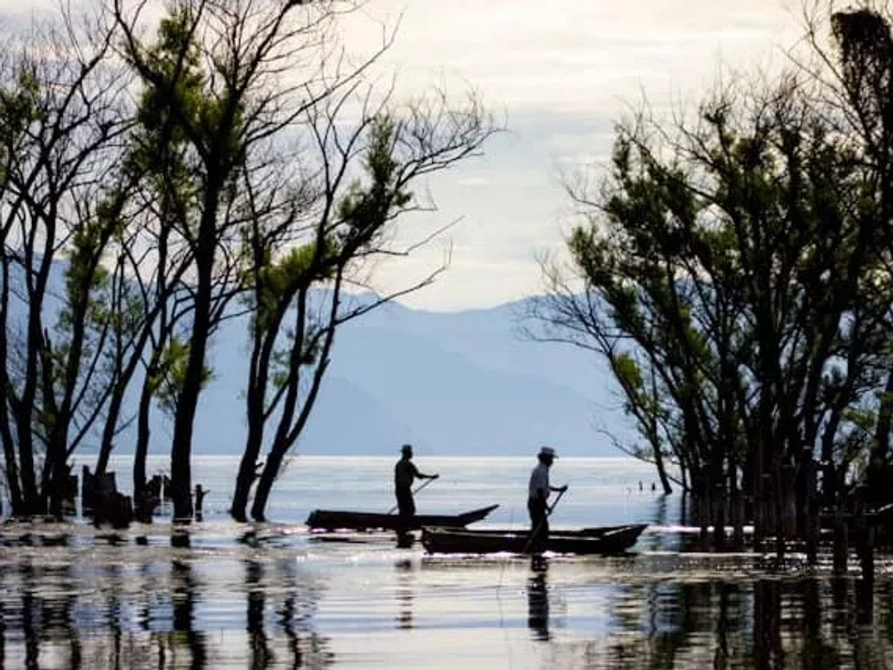 dois senhores um barco a remo no Lake Atitlán, Guatemala