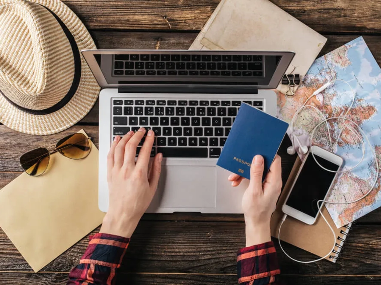 pessoa com passaporte na mao e a mexer no computador