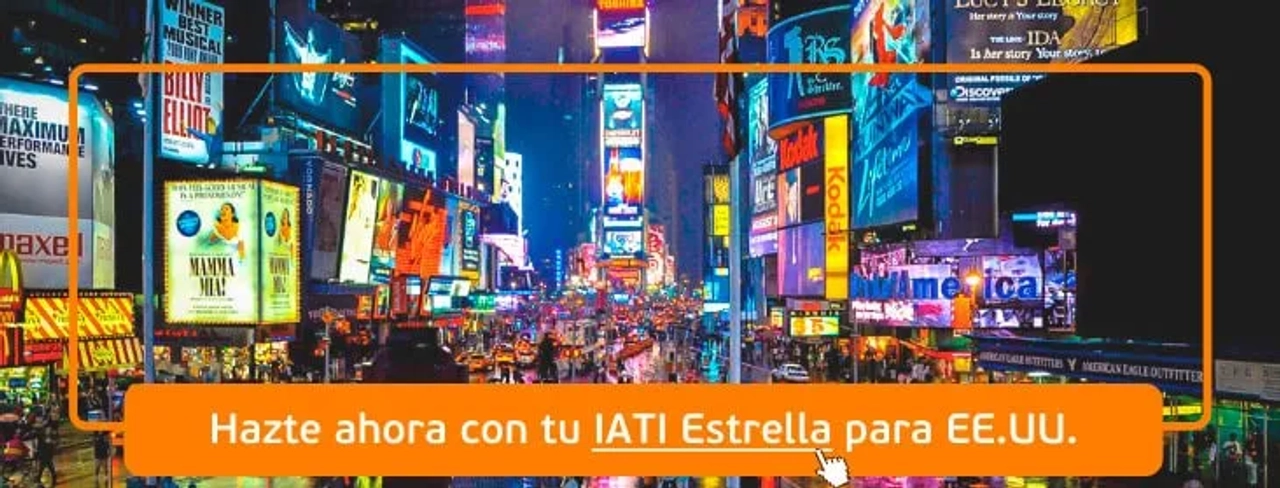Vista nocturna de Times Square, con luces brillantes y anuncios publicitarios.