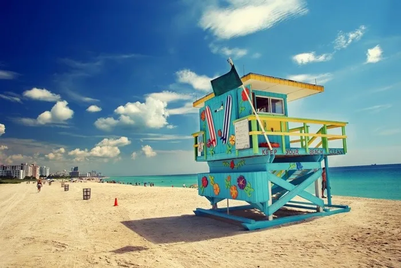 Torre de salvavidas colorida en la playa de Miami, con mar y cielo despejado.