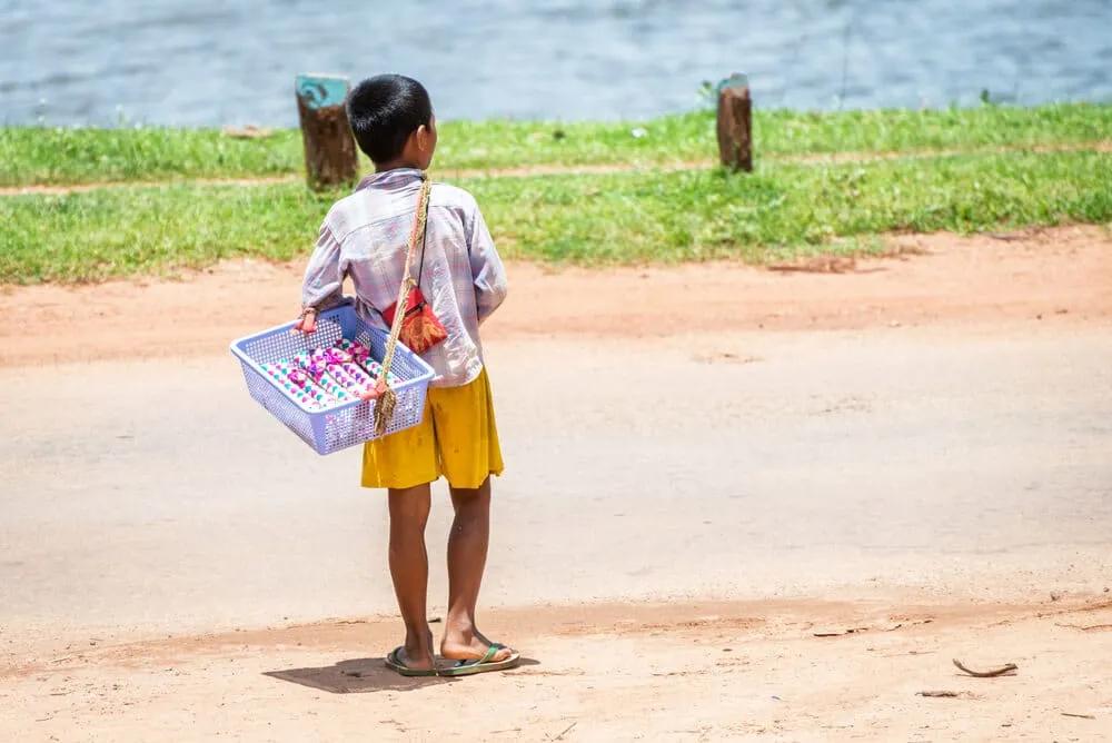 criança de costas a vender pulseiras
