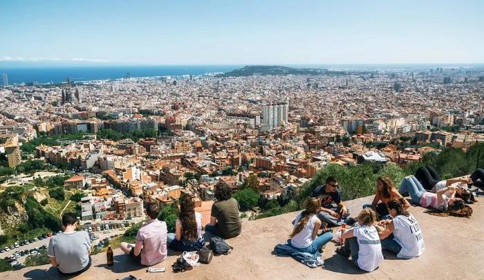 Vista panorâmica de Barcelona com pessoas relaxando em um miradouro.