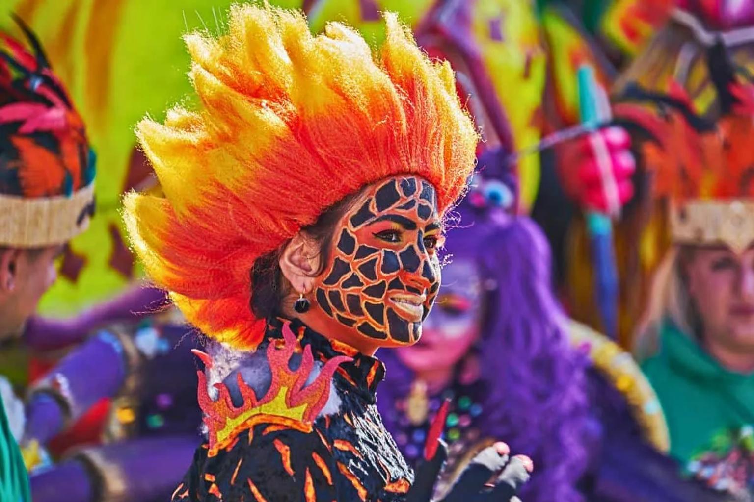 Mujer con maquillaje colorido y peinado llamativo en el Carnaval de Río de Janeiro.