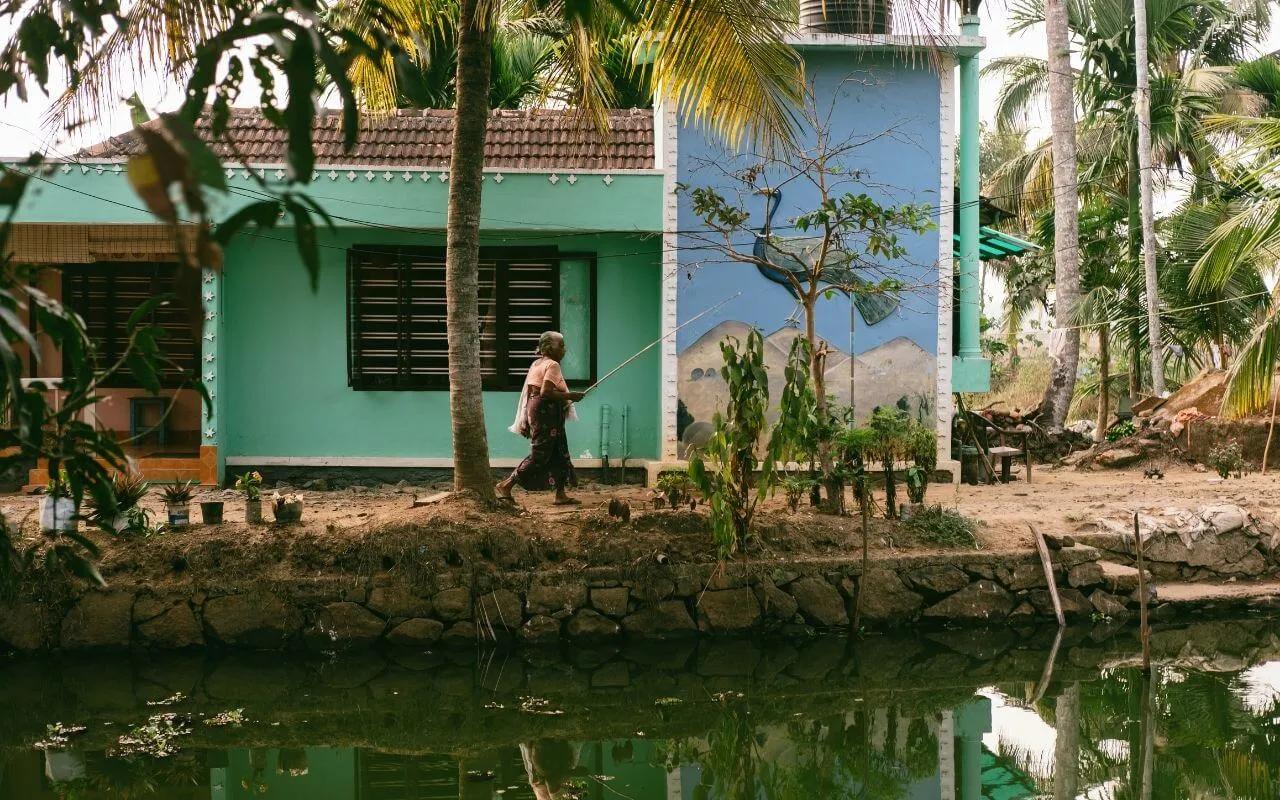 mulher com cana de pesca ao ombro caminha pela estrada