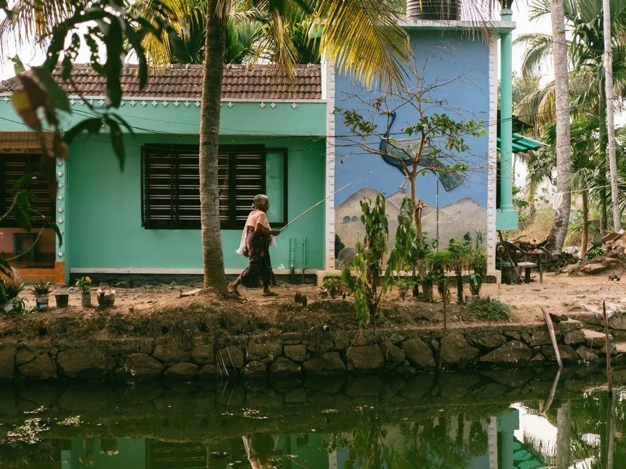mulher com cana de pesca ao ombro caminha pela estrada