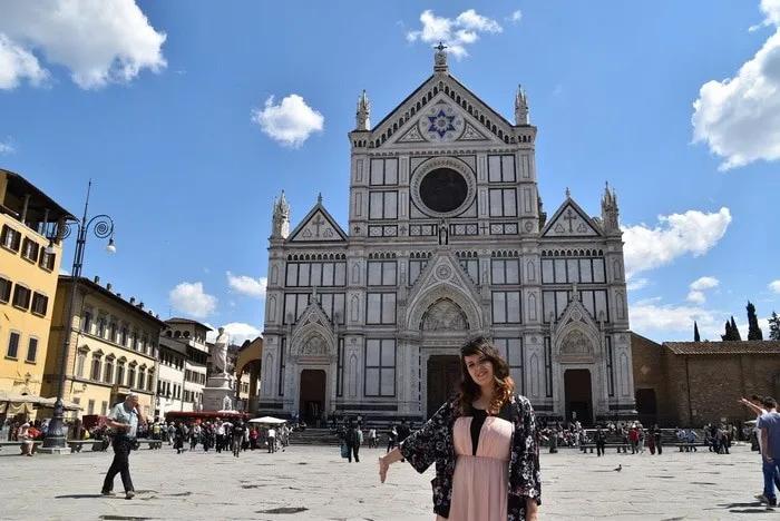 Mujer sonriente frente a la Basílica de Santa Croce en Florencia.