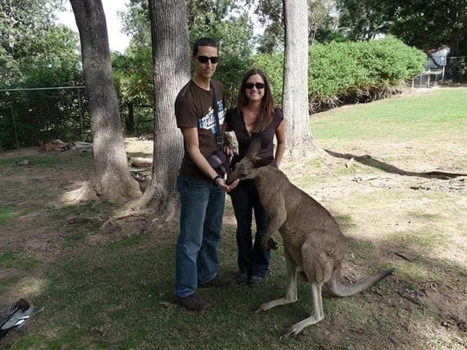 Pablo y Elena posan junto a un canguro en un parque.