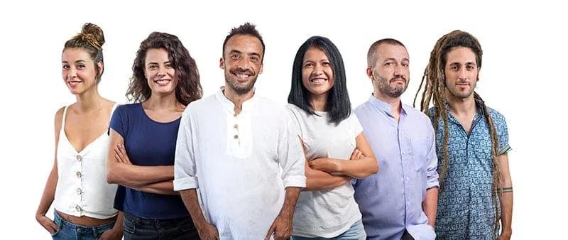Grupo de seis personas sonriendo, posando juntas en un fondo blanco.