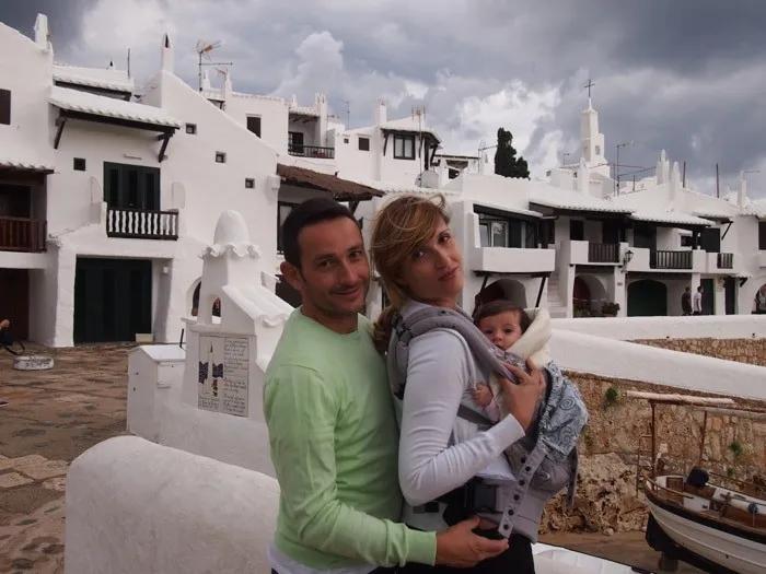Familia con un bebé en un destino turístico de casas blancas.