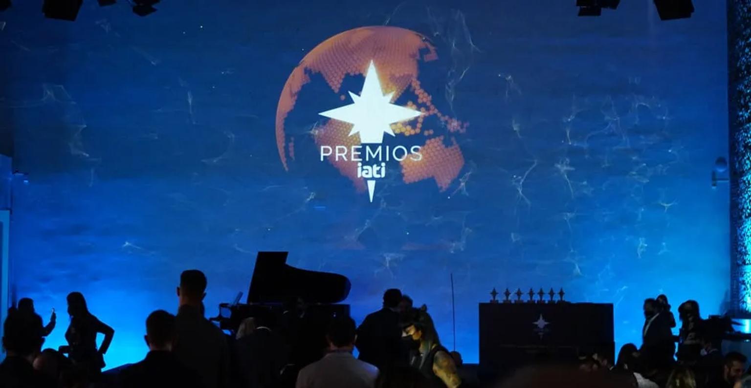 Ceremonia de los Premios IATI 2022 con proyección de logo y asistentes.