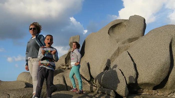 Familia posando en rocas, disfrutando de un día al aire libre.