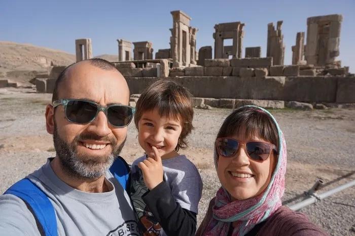 Familia sonriente en un sitio arqueológico, disfrutando de un viaje juntos.
