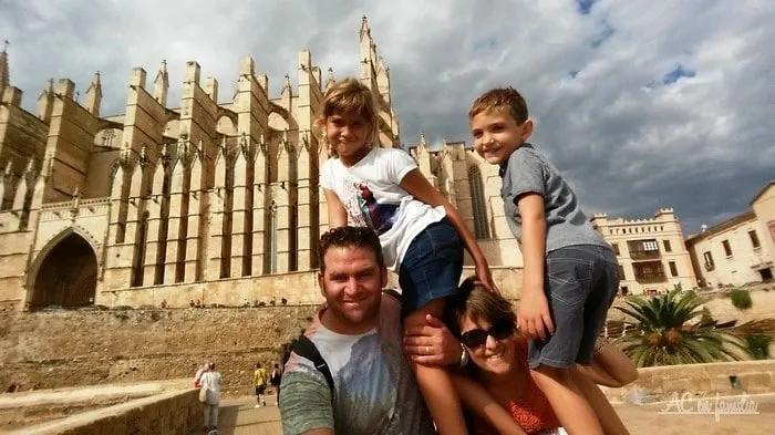 Familia posando frente a una catedral, disfrutando de un día soleado.