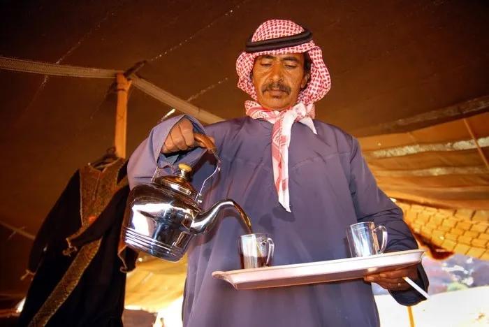Hombre sirviendo té en un entorno tradicional beduino en Jordania.