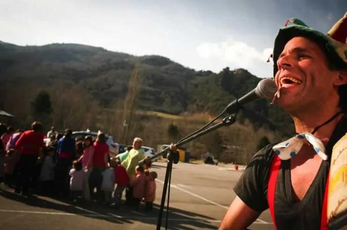 Artista animando a un grupo de familias al aire libre en un evento.