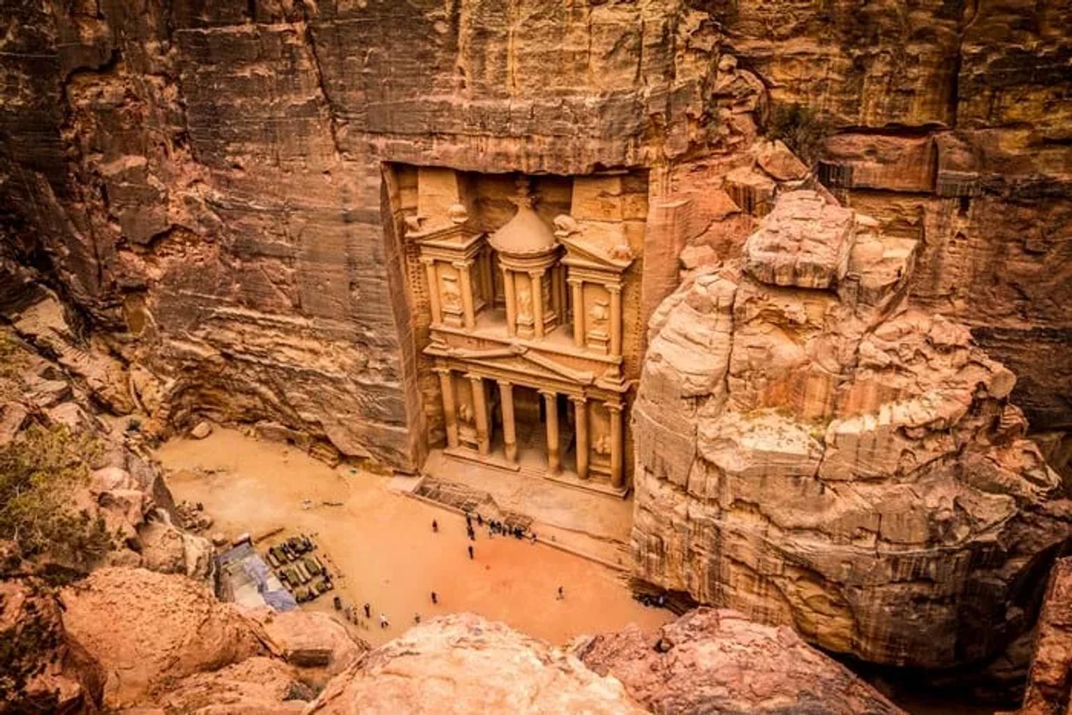Vista de Petra, antigua ciudad tallada en roca, rodeada de montañas.