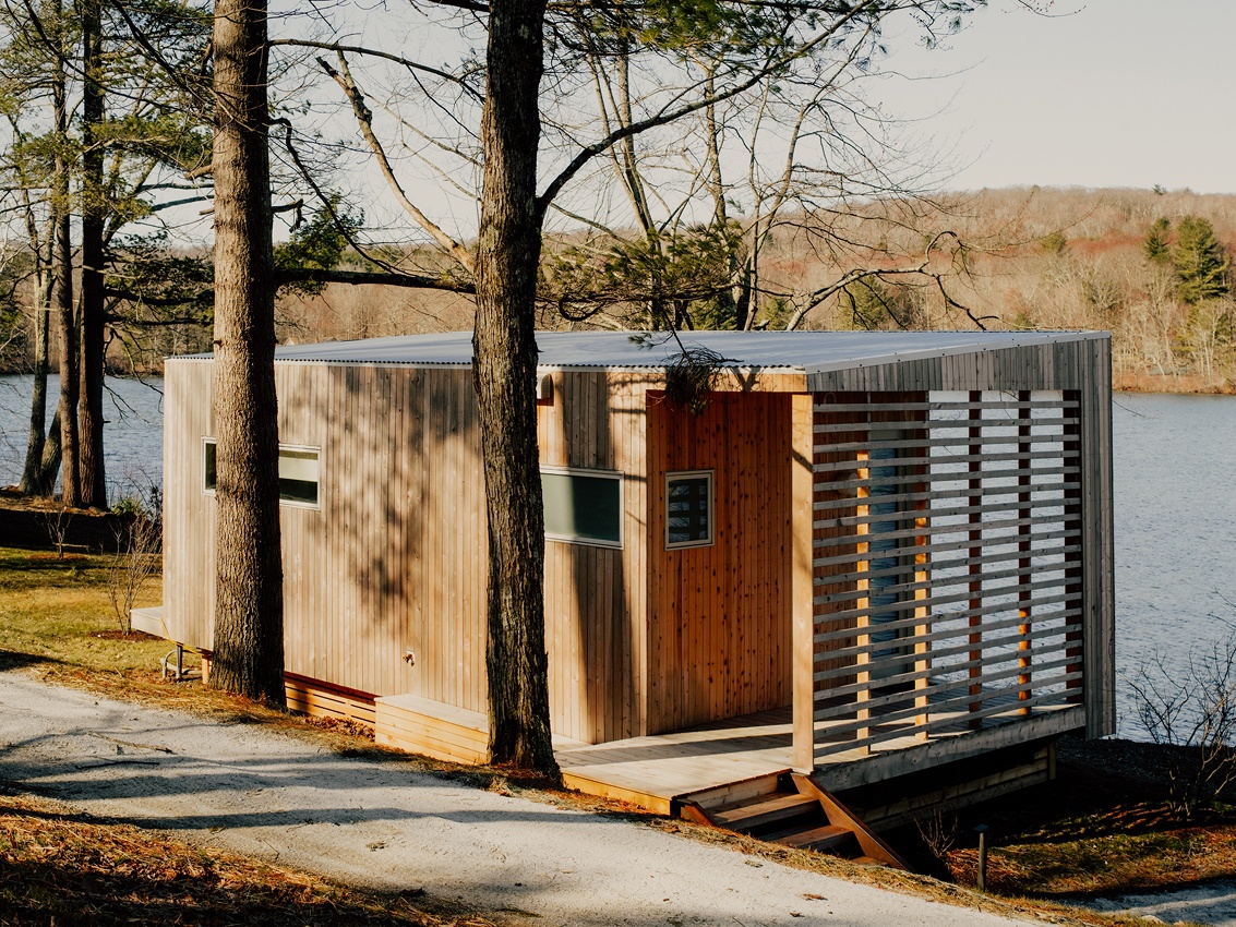 a wooden building surrounded by trees with a blue sky