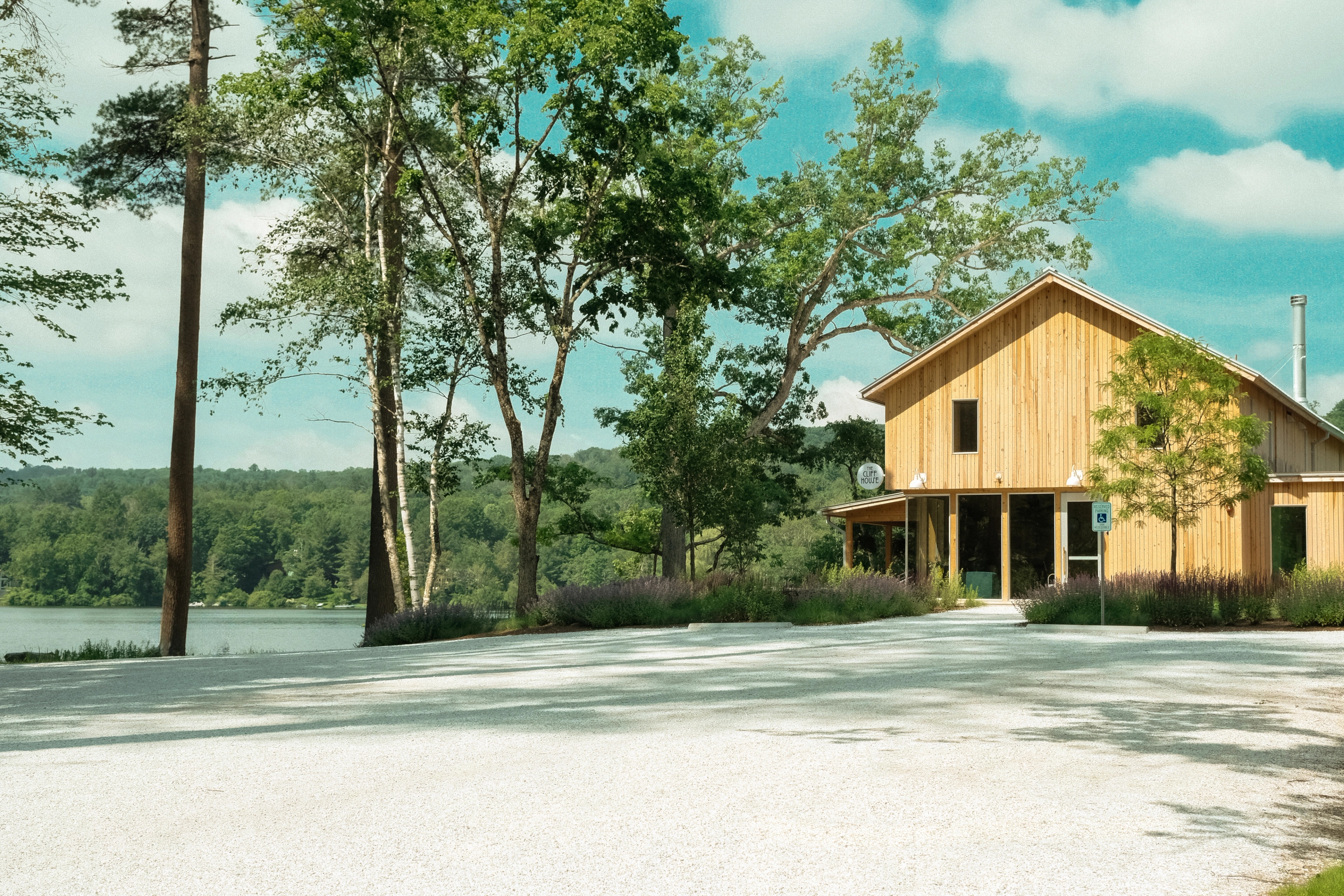 a wooden building surrounded by trees with a blue sky