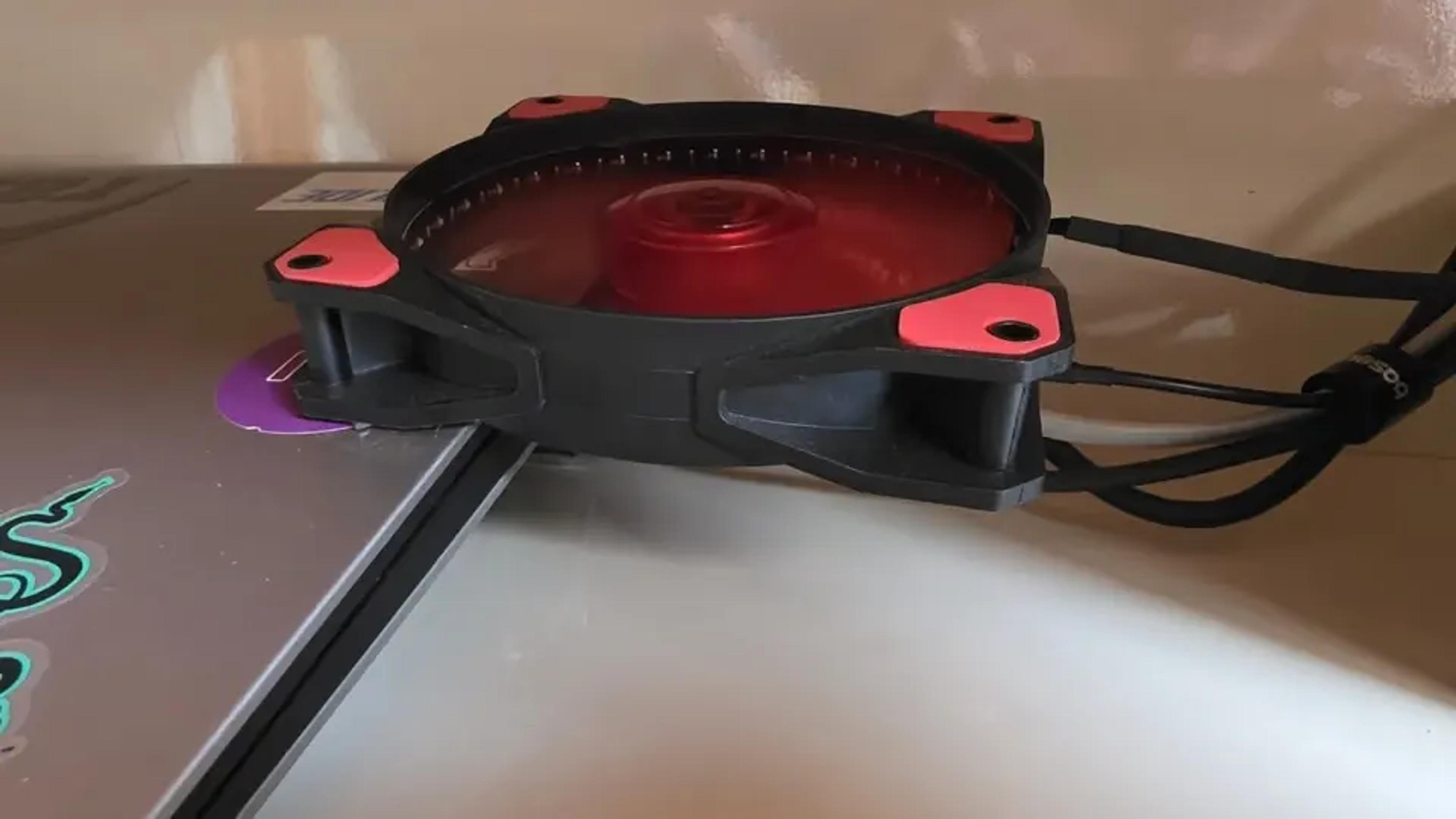 Ventilador vermelho de computador posicionado junto ao notebook e ao receptor