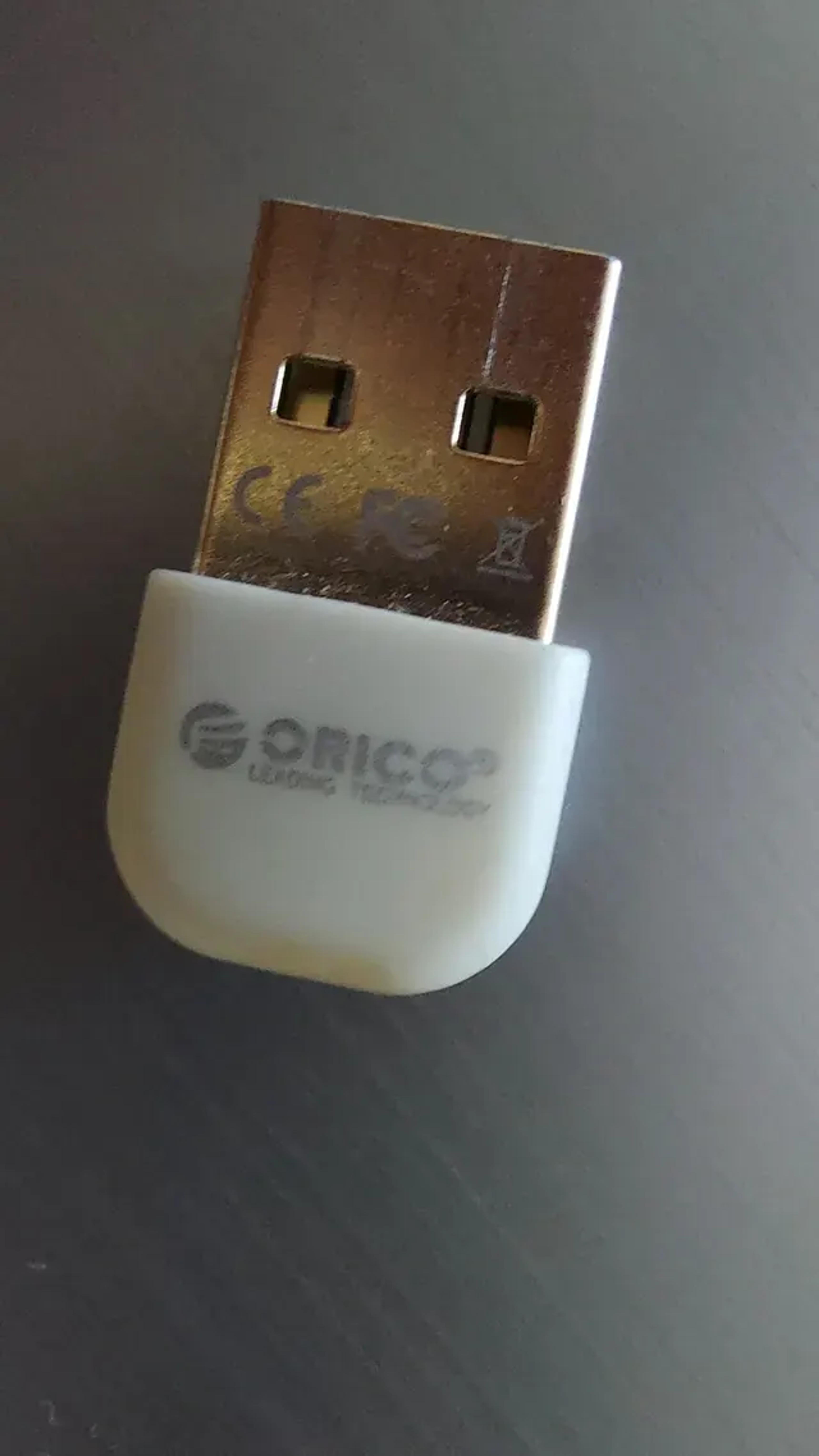 Adaptador USB Bluetooth da Orico sobre uma superfície neutra
