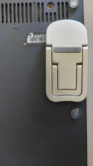 Detalhe do pé dobrável instalado na base do notebook junto à grade de ventilação