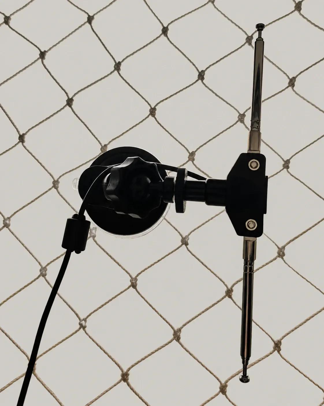 Antena dipolo telescópica presa por ventosa à janela, com o entorno externo removido