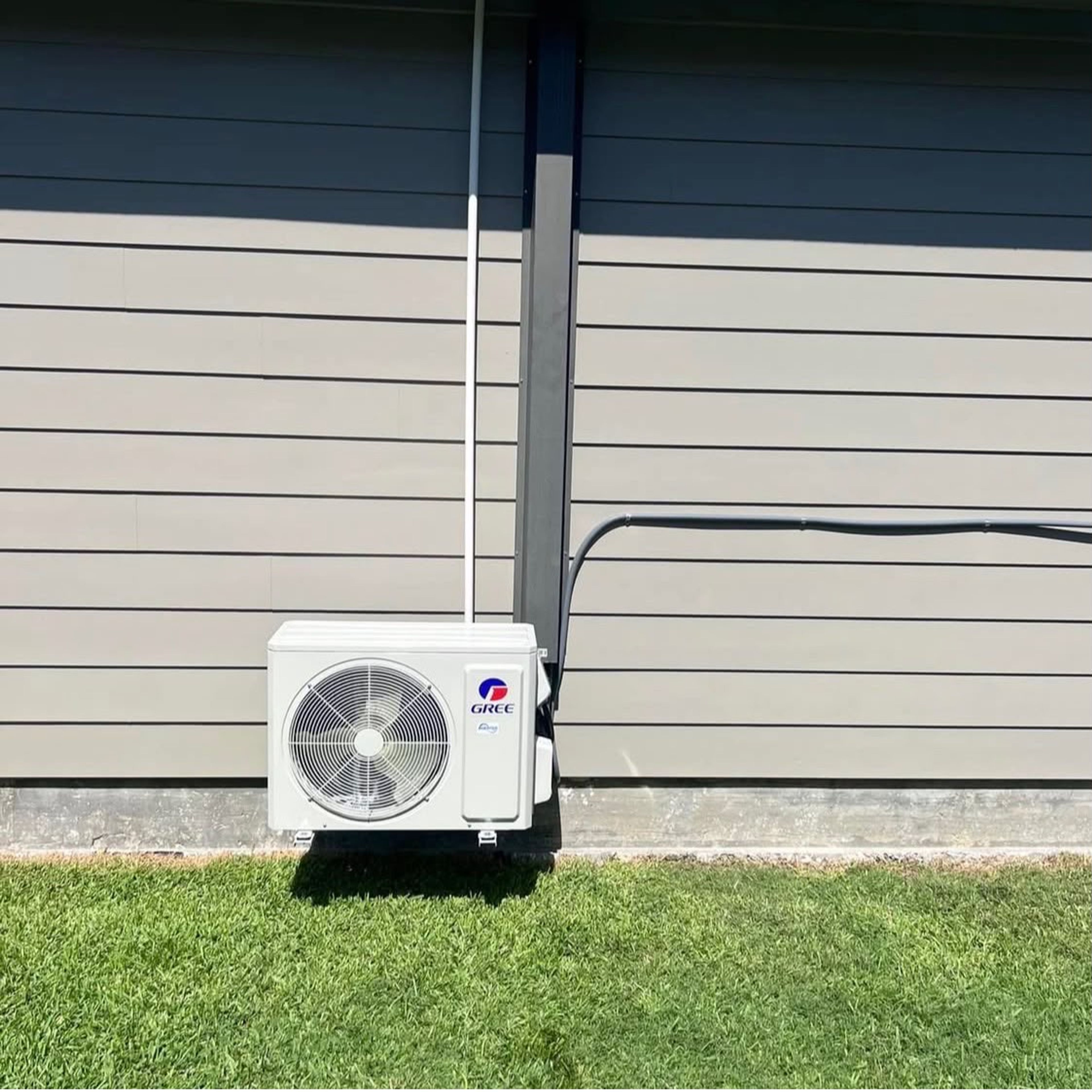 Ductless mini-split condenser installed beside a residential home