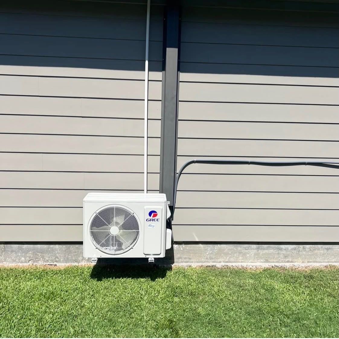 Ductless mini-split condenser installed beside a residential home