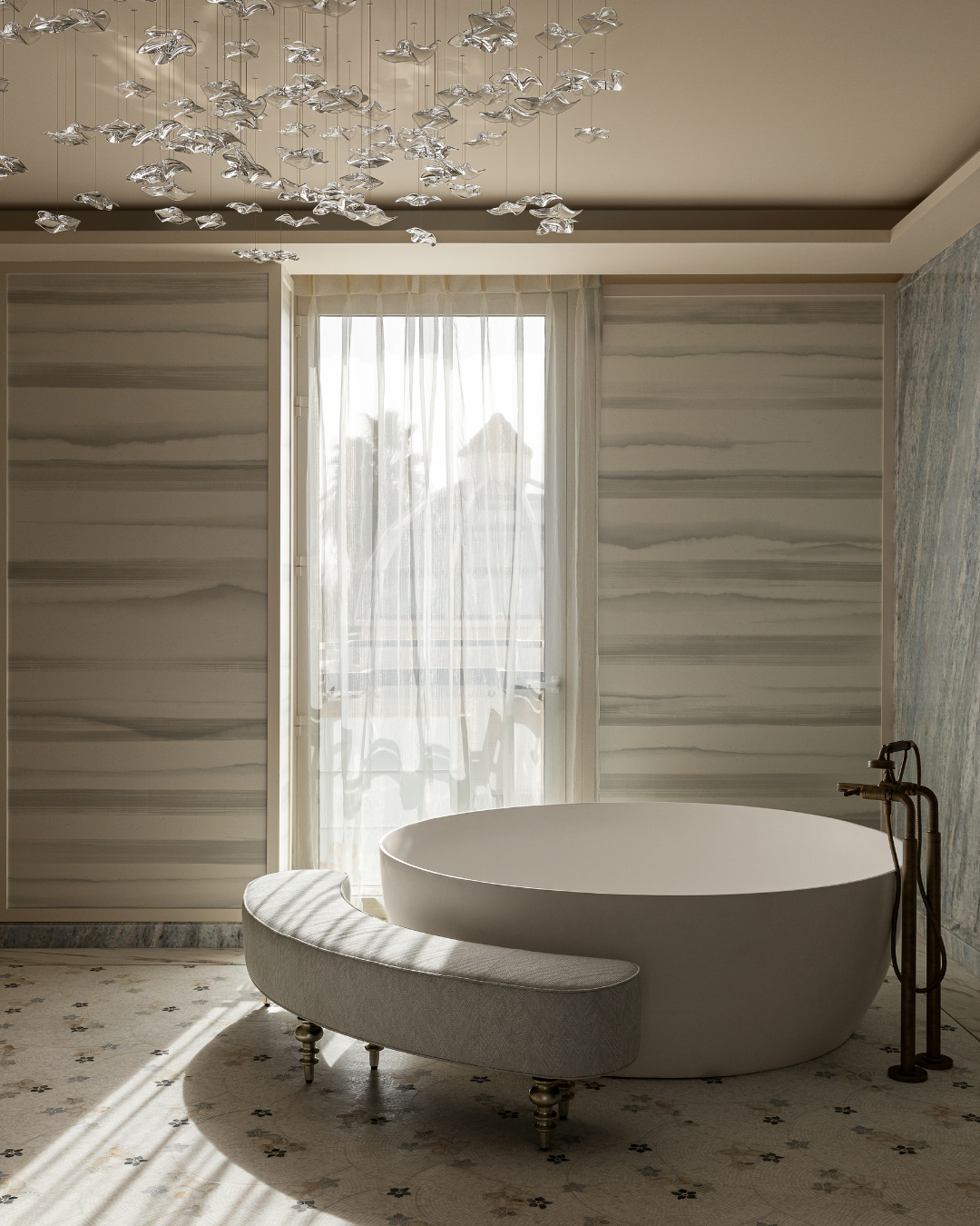 Dubai family villa master suite bathroom with freestanding bath, veined stone walls and soft daylight filtered through sheer curtains.