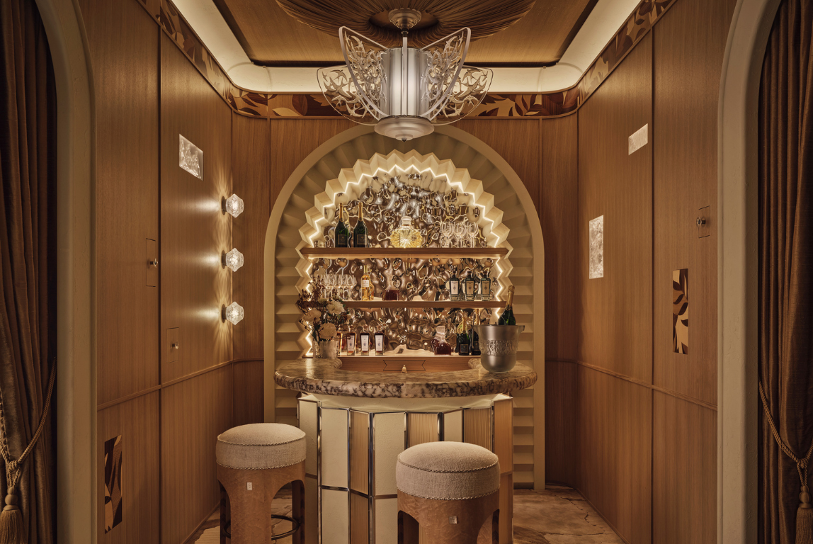 Art Deco-inspired private bar with sculptural lighting, warm timber panelling and a marble counter, designed by Elicyon.