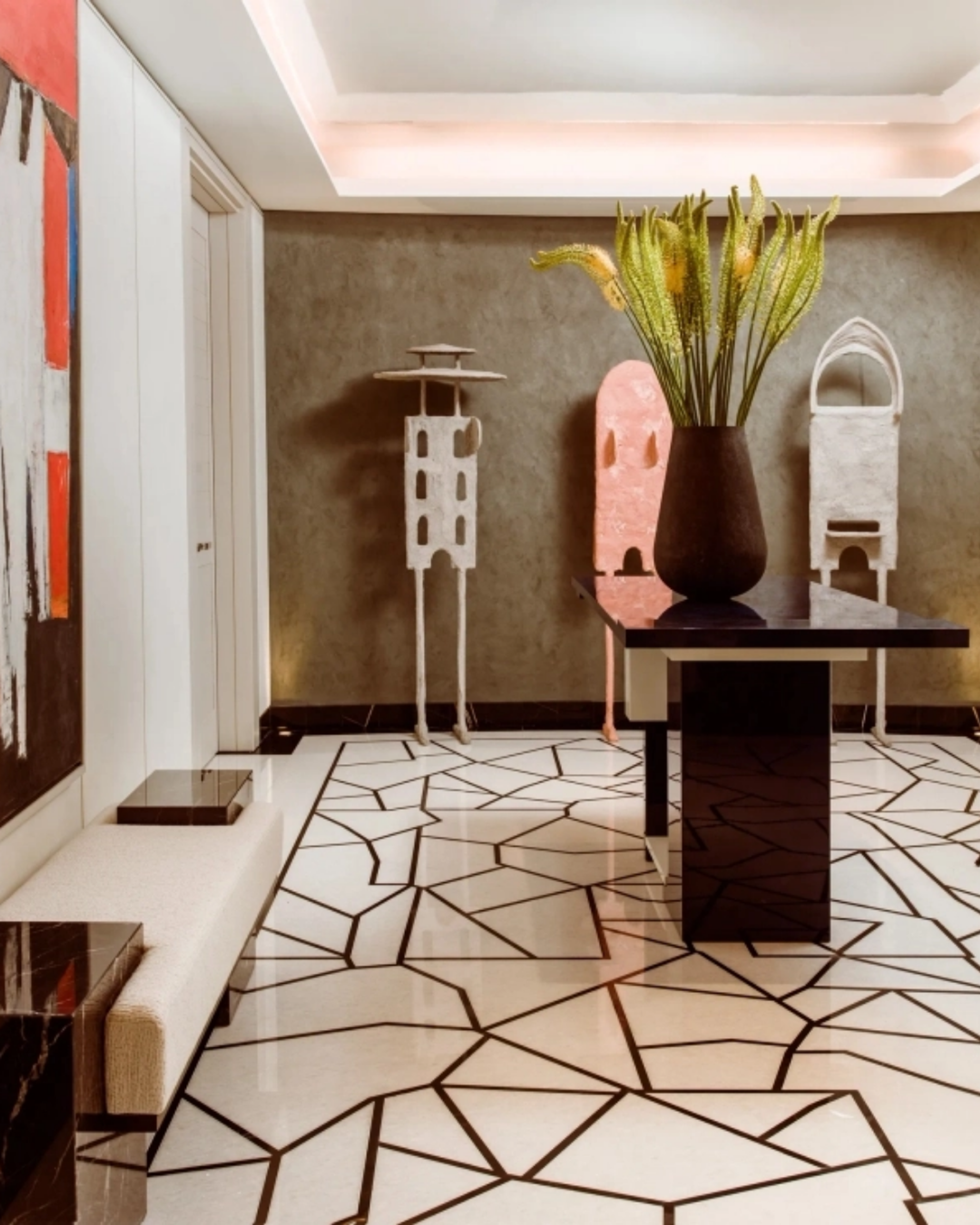 Contemporary entrance hall at One Hyde Park featuring a geometric stone floor, sculptural artworks, statement floral arrangement and custom furniture.