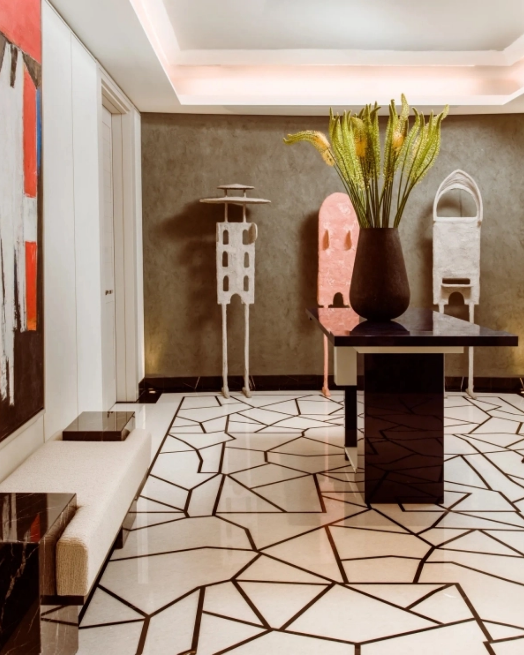 Contemporary entrance hall at One Hyde Park featuring a geometric stone floor, sculptural artworks, statement floral arrangement and custom furniture.