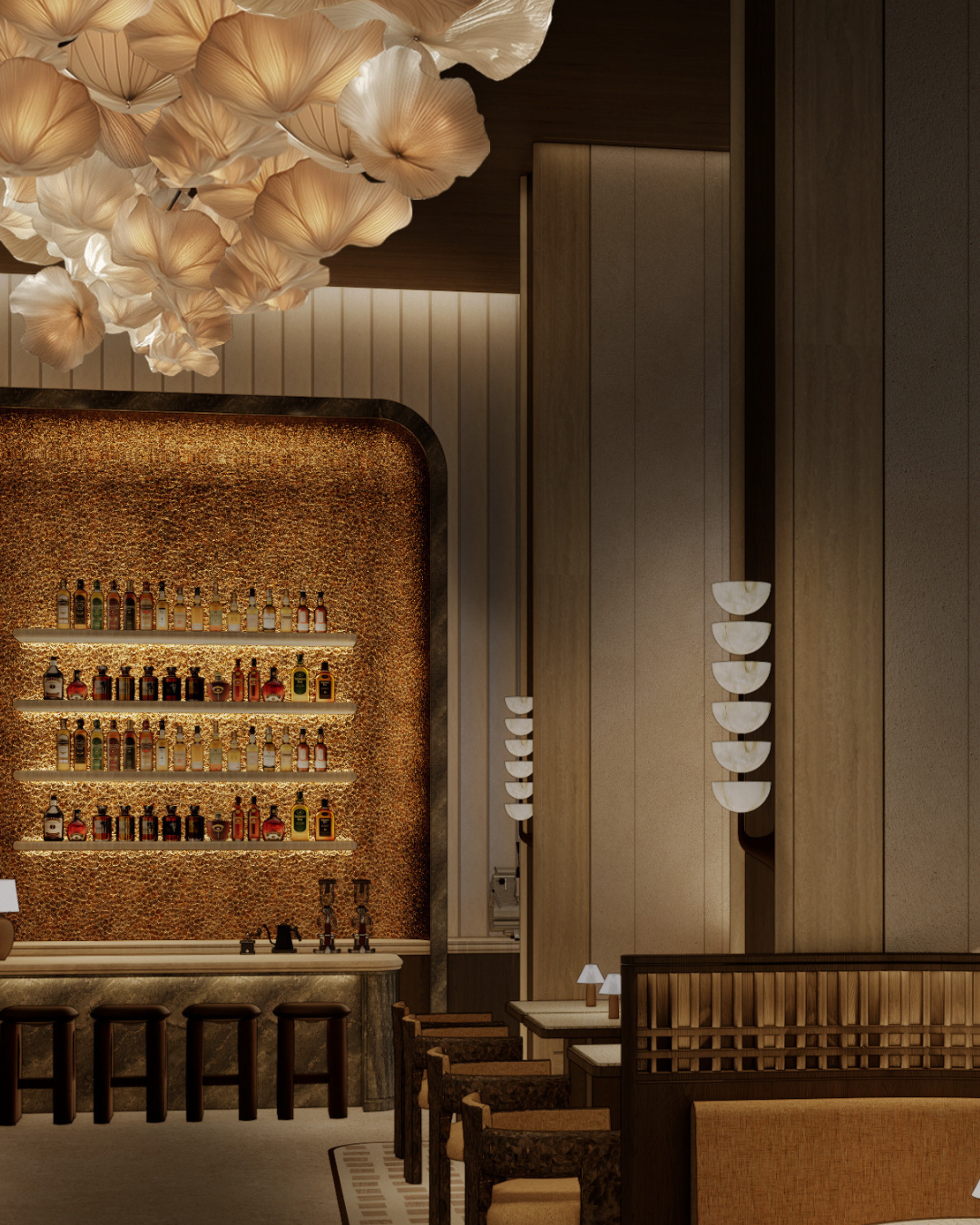 A softly lit bar framed by warm timber panelling and fluted wall detailing, centred around a textured amber backdrop with floating shelves and a sculptural petal-like chandelier overhead.