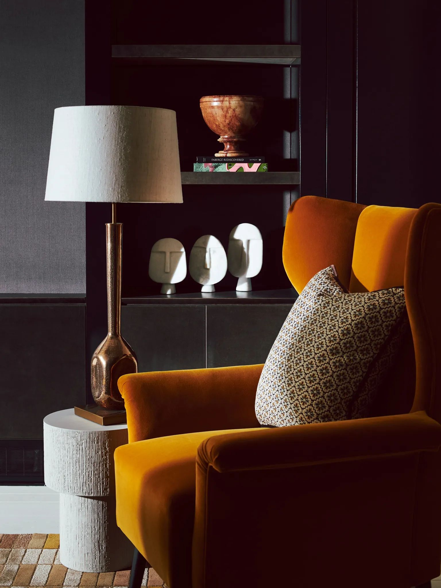 luxury interior orange velvet arm chair with a cushion, concrete side table and lamp
