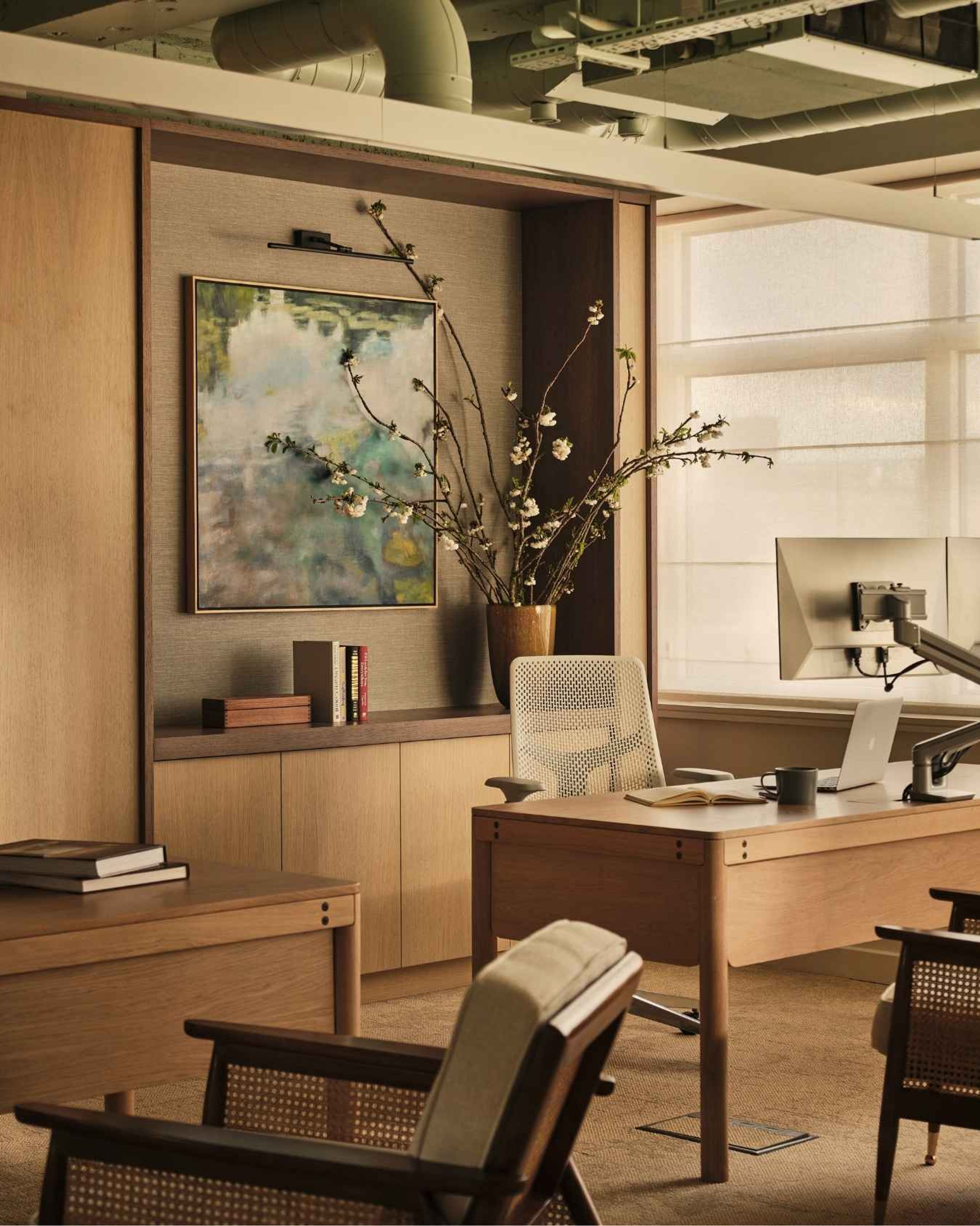 Contemporary private office featuring bespoke oak joinery, an executive desk, abstract artwork and warm natural finishes.