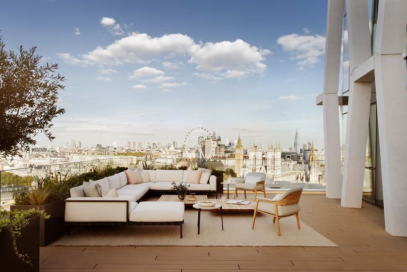 A rooftop terrace with an outdoor sofa and chairs.