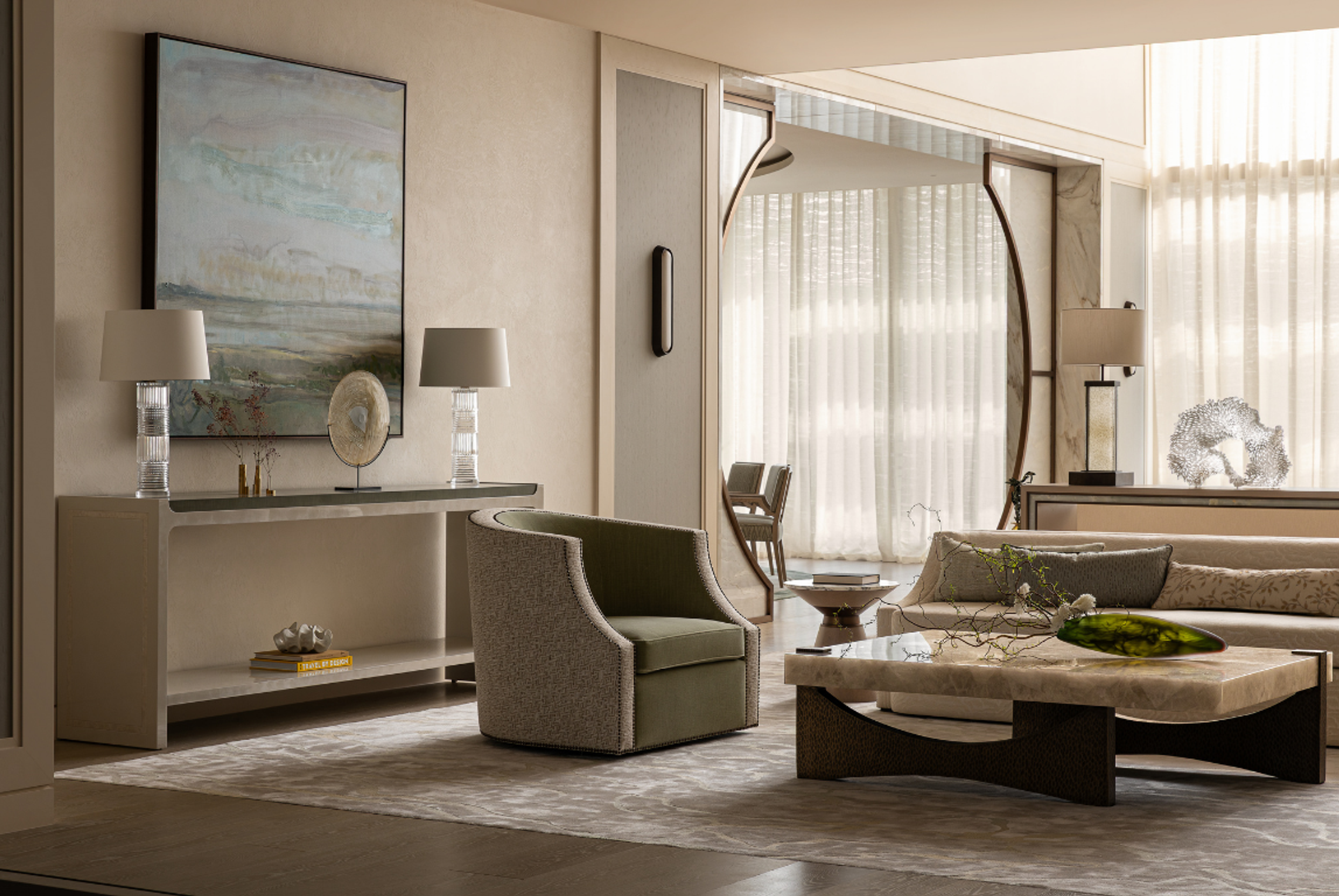A calm living space with neutral tones, featuring a sculptural coffee table, tailored armchair and large circular mirror that frames filtered daylight through sheer curtains.