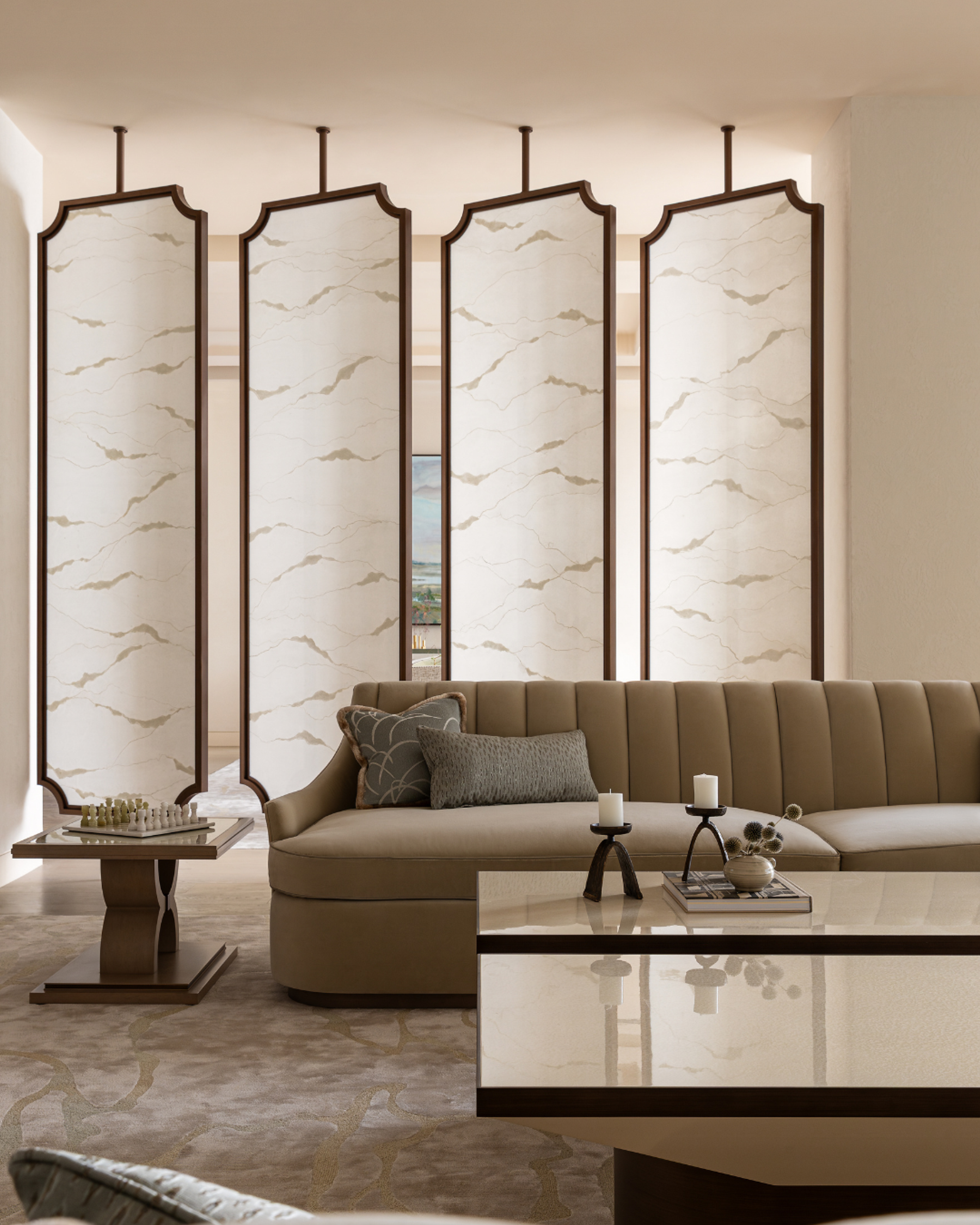 Laminated washi paper panels filter light in a serene Dubai majlis, framing a curved banquette and refined tables in a palette of soft neutrals.
