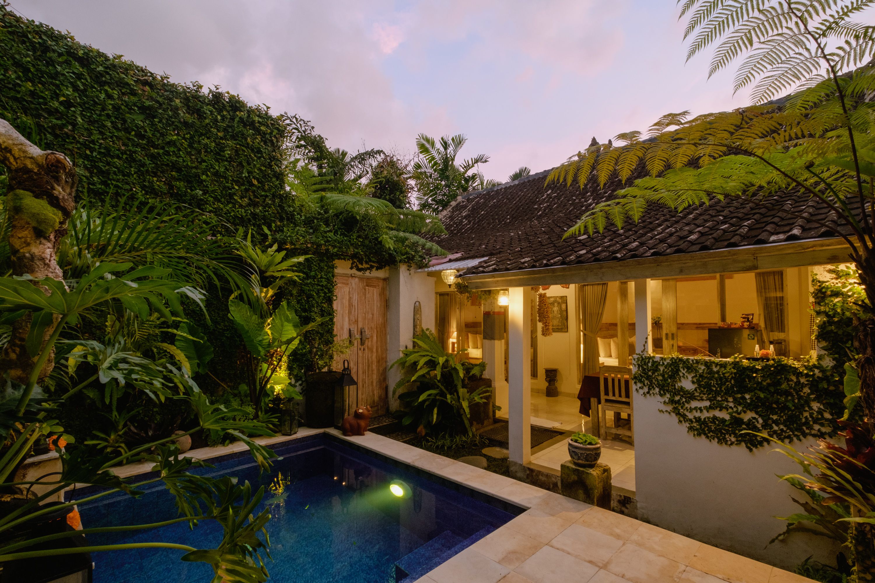 Private pool and villa lit up at dusk