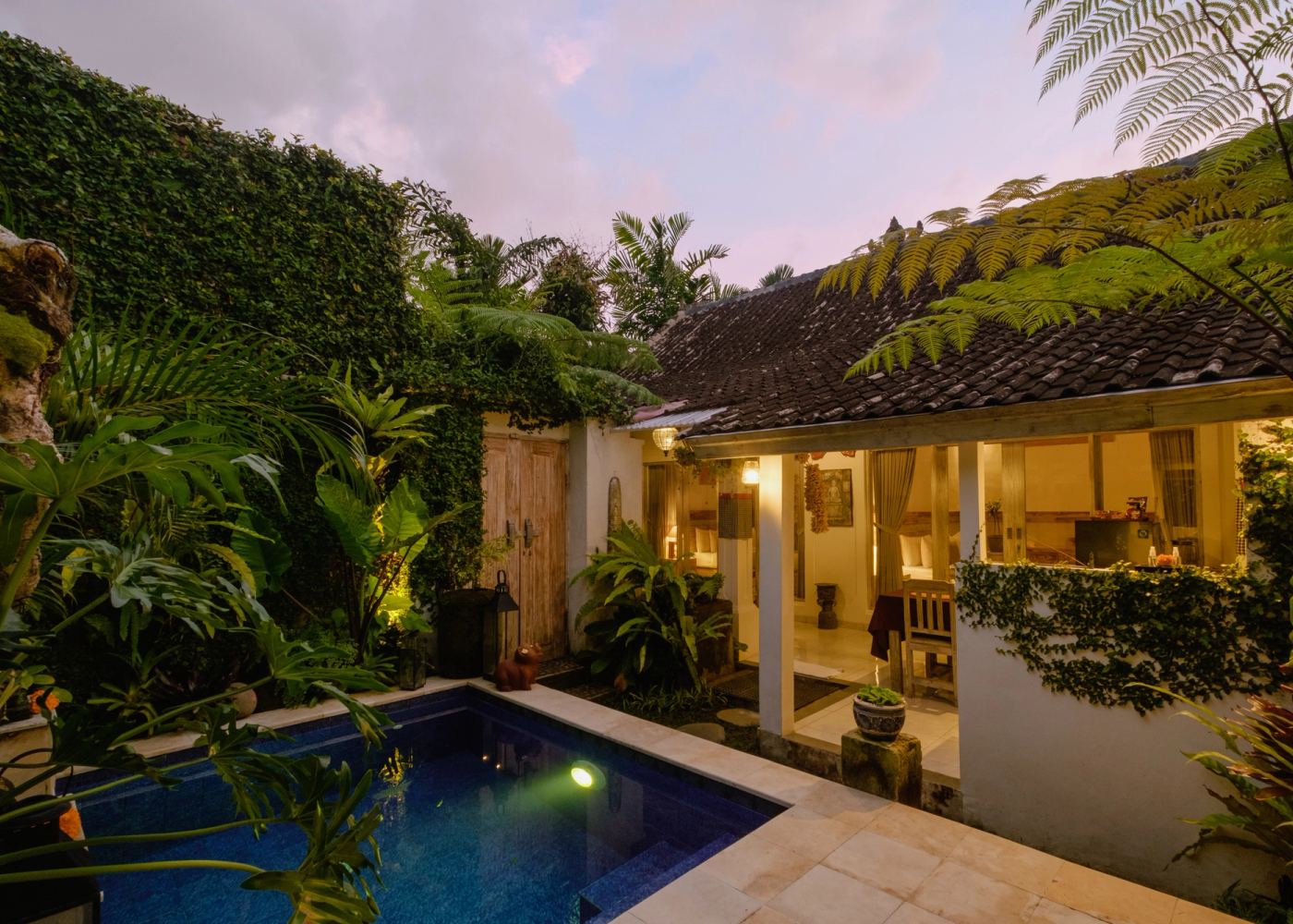 Private pool and villa lit up at dusk