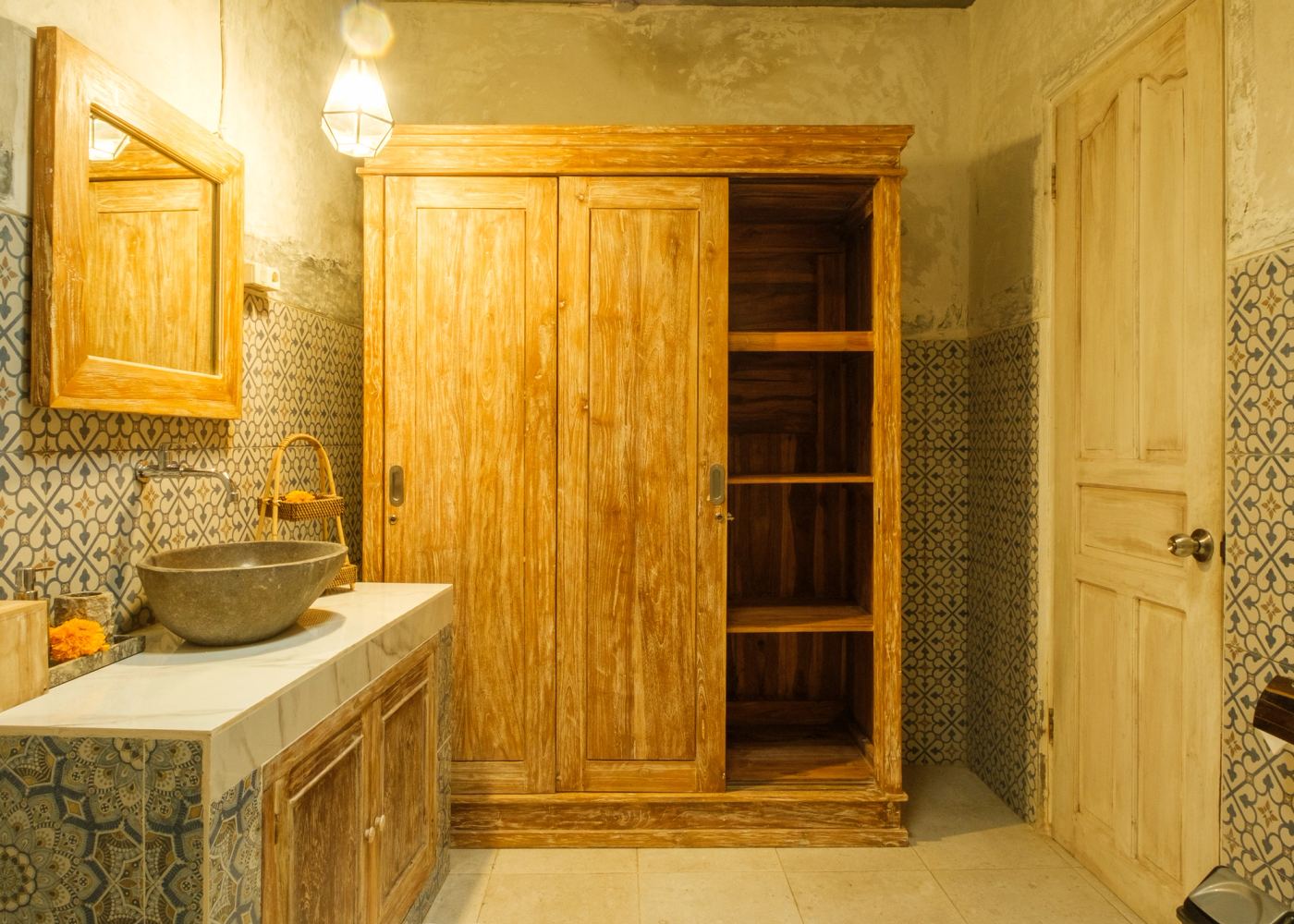 Bathroom with stone basin and teak wardrobe