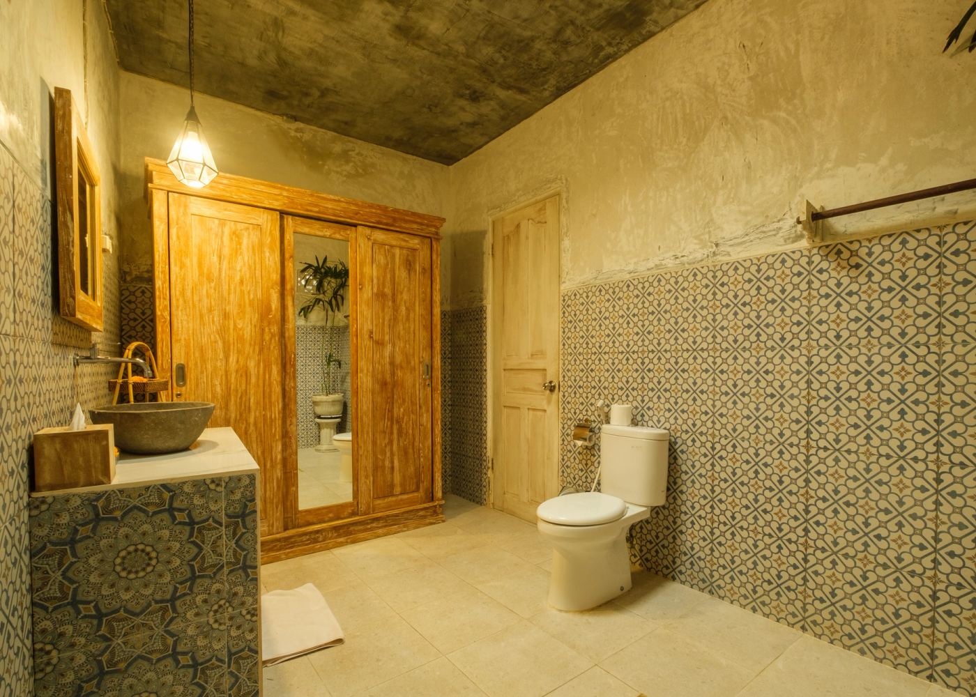 Bathroom with teak wardrobe and patterned tiles