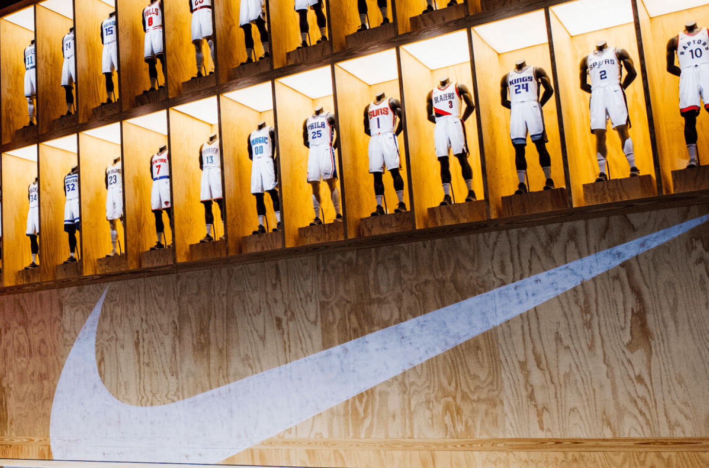 basketball jerseys lined up above nike logo