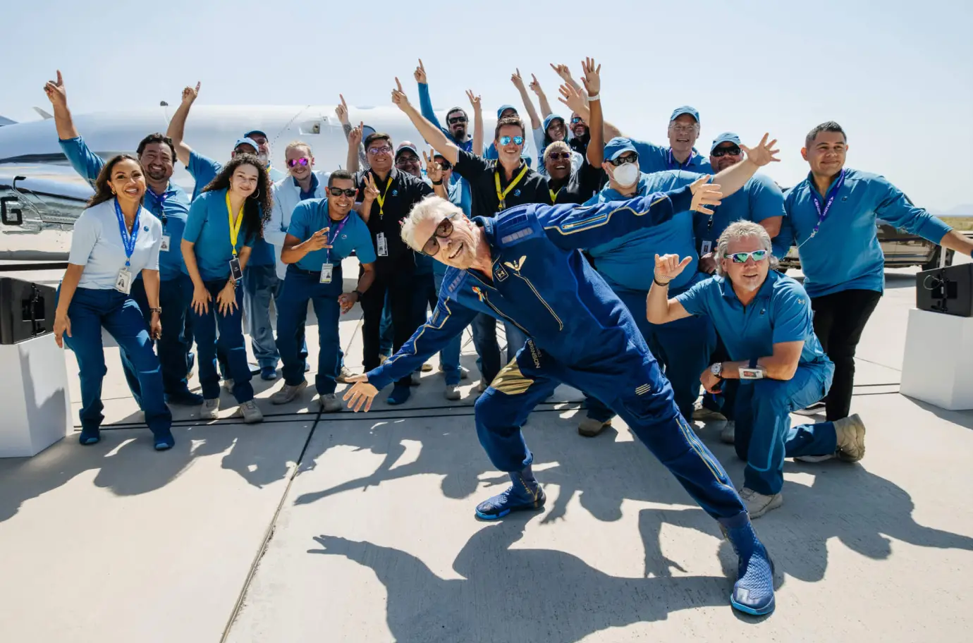 group gathered in front of a plane on tarmac
