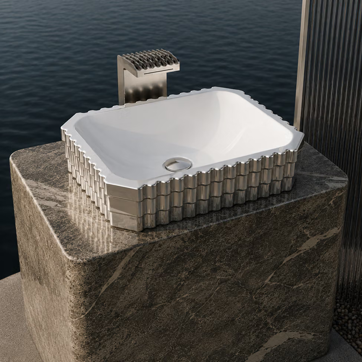 White rectangular countertop basin with a fluted silver exterior on a stone block above calm water