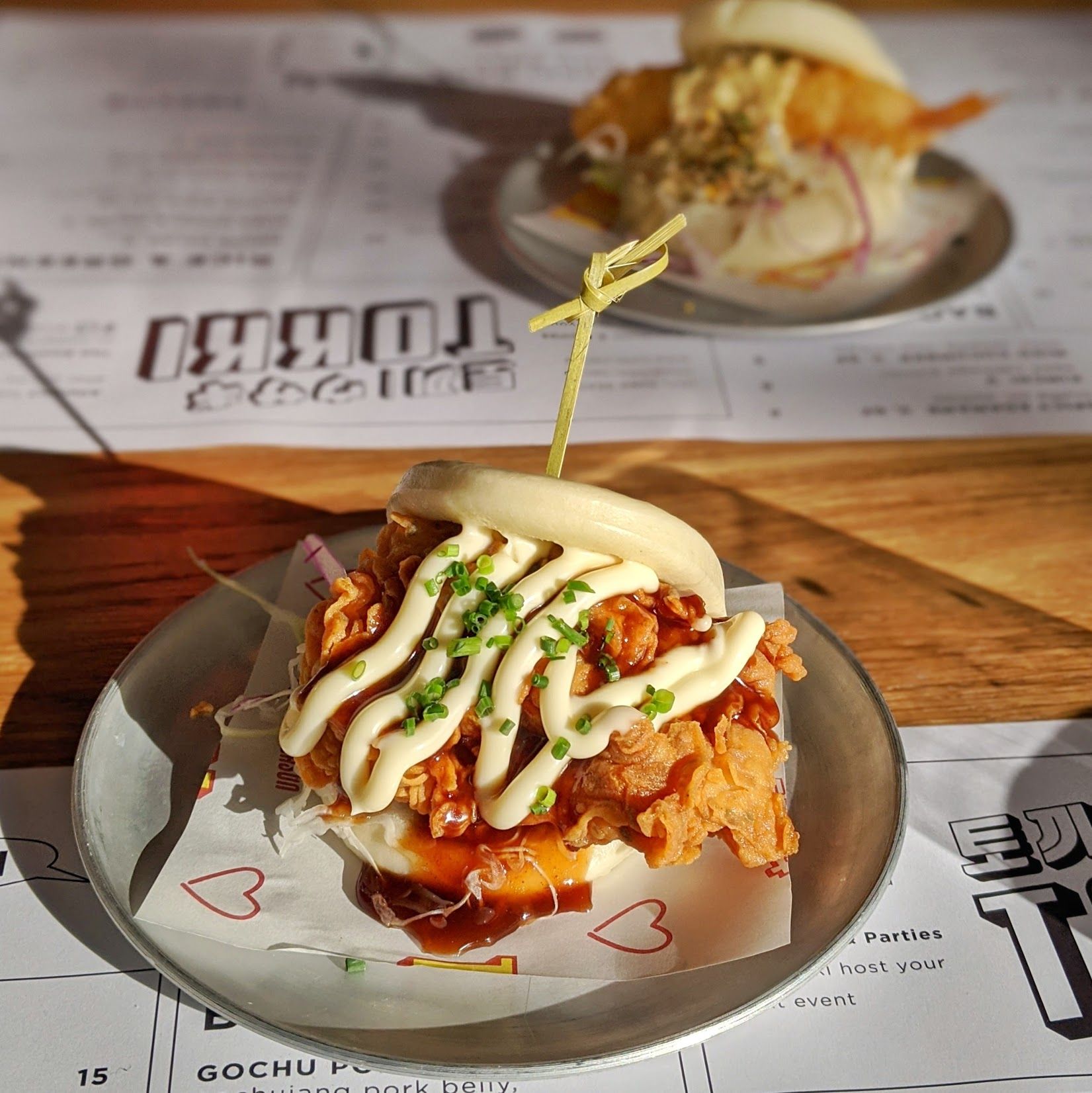 Fried chicken bao in the foreground and prawn katsu bao in the background