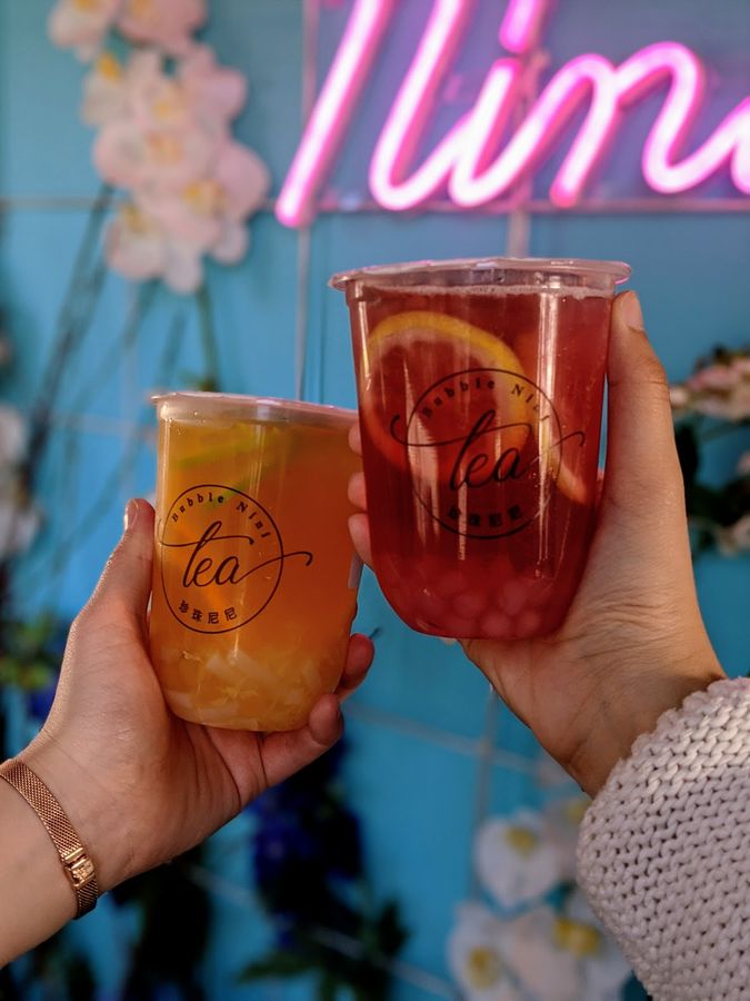 Hands holding two cups of bubble tea