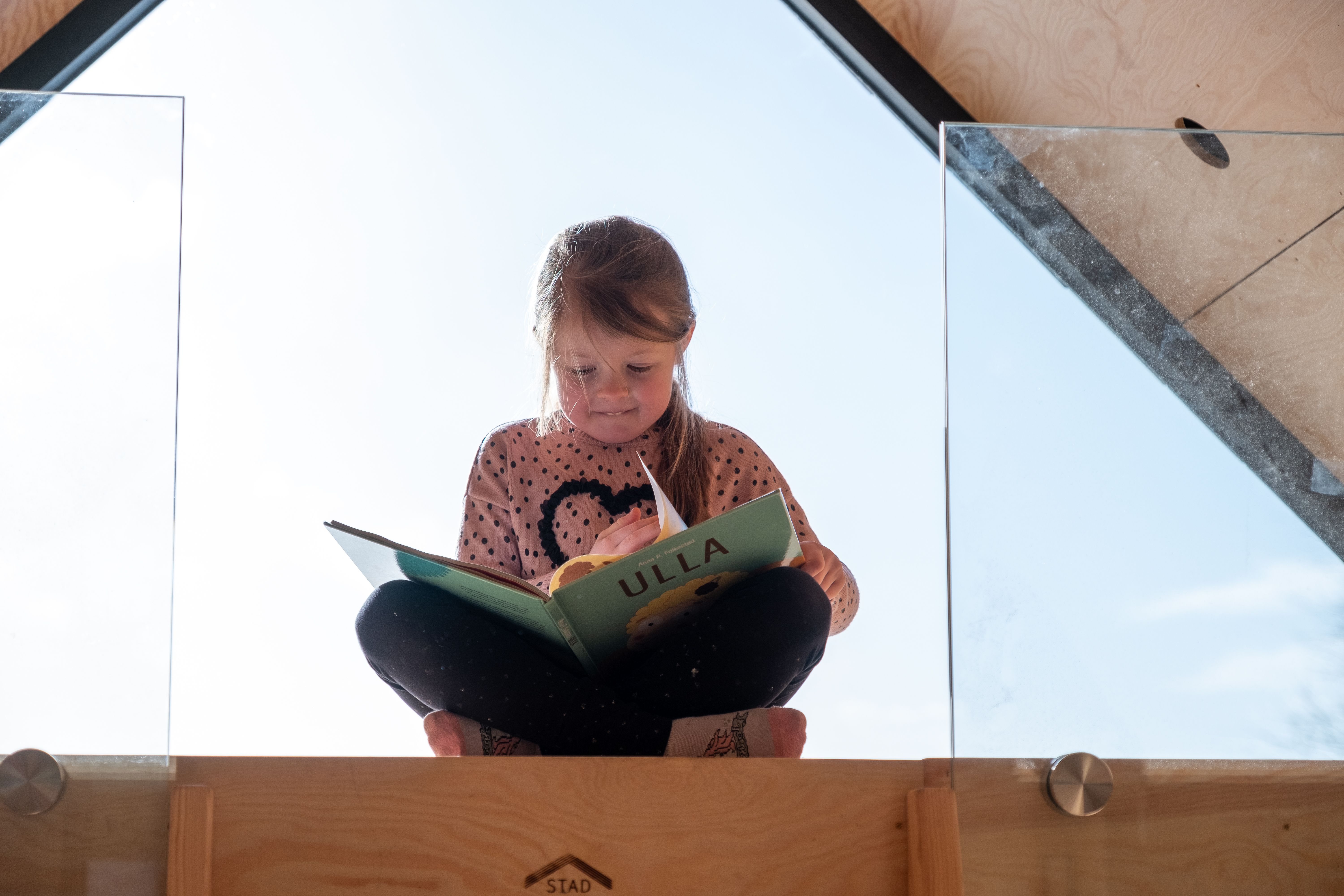 Jente leser bok på hemsen