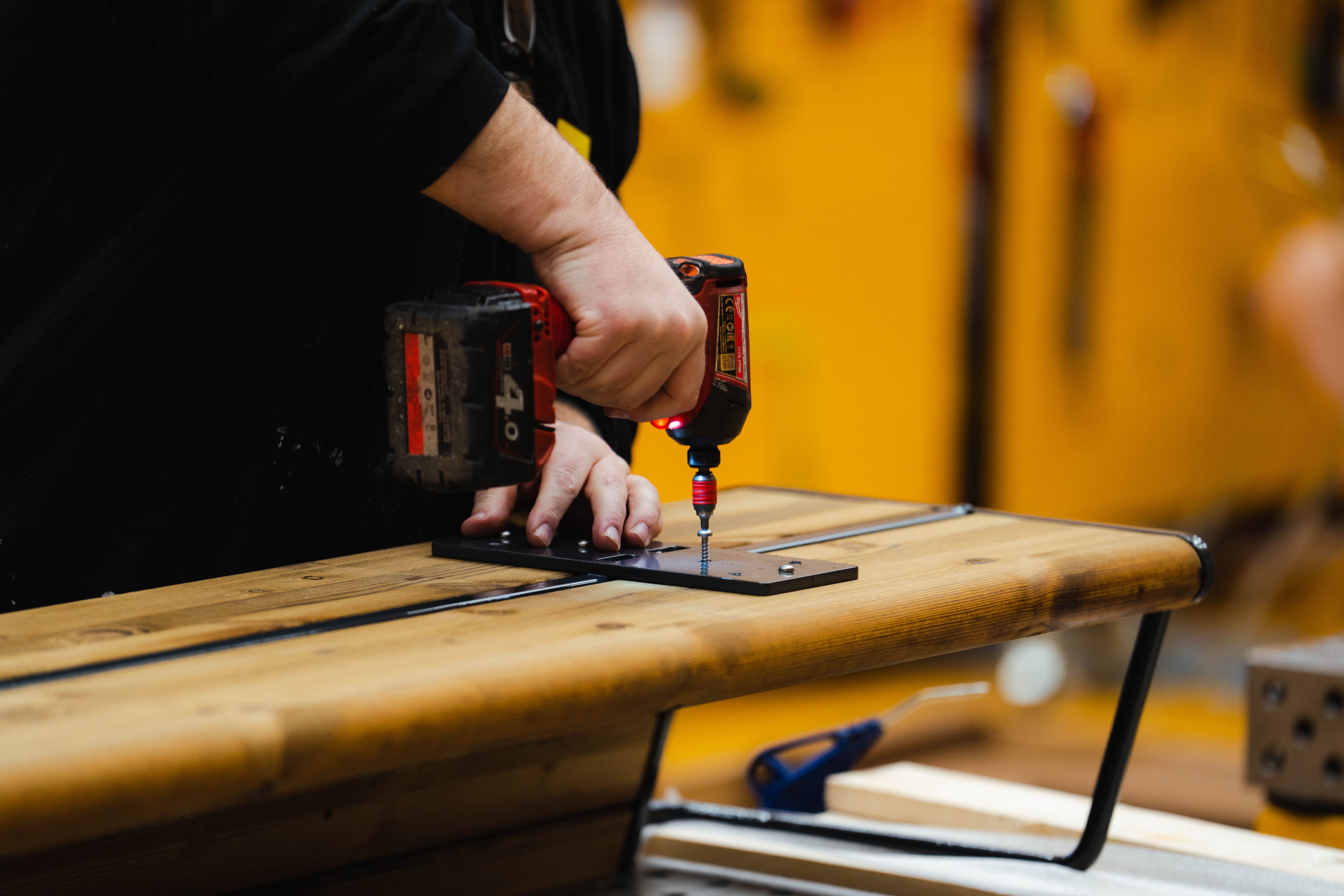 En ansatt monterer møbler på The Plus. 