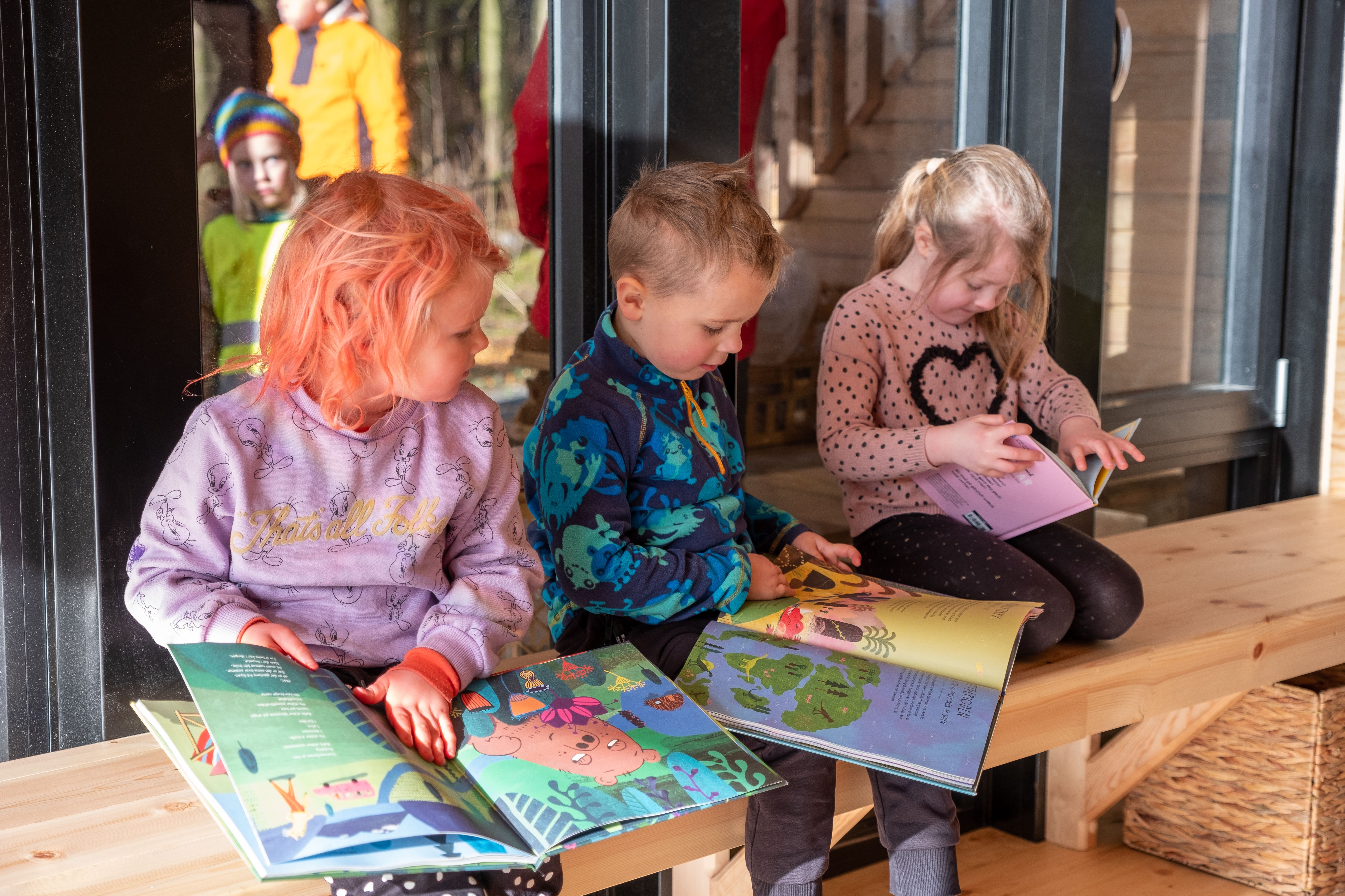 Barn som koser seg og leser